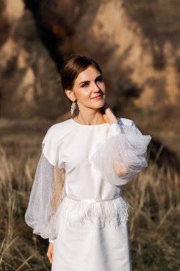 Güneşli bir günde poz veren şık bir gelin..