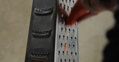 Öğütücüde havuç dilimleme, sadece yakın plan eller. Sağlıklı beslenme