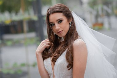 Genç, neşeli bir düğün çifti. Duvağı olan bir gelin, siyah takım elbiseli çekici bir damat..