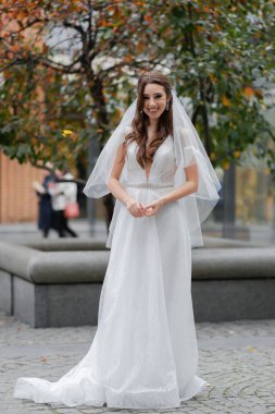 Genç, neşeli bir düğün çifti. Duvağı olan bir gelin, siyah takım elbiseli çekici bir damat..