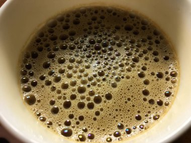 Masanın üzerinde bir fincan kahve, yakın plan. Çalışma ortamı. Bir sürü baloncuk