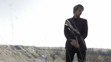 Siyahlar içinde düşünceli ve heyecanlı bir adam. Gergin ve endişeli. Depresyon ve kendini keşfetme. Orman ve açık alan