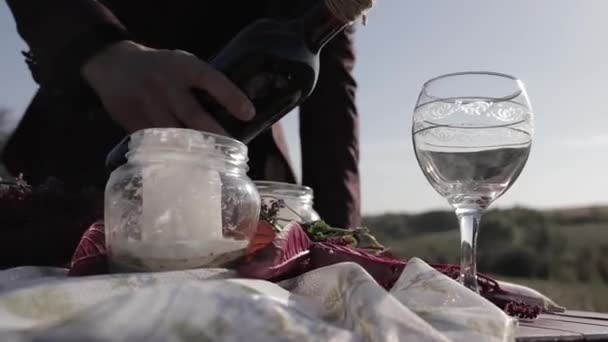 Man Häller Vin Glas Ett Träbord Ett Öppet Fält — Stockvideo