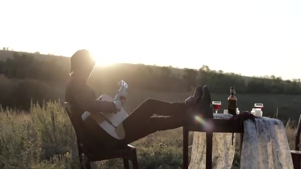 Musikern Spelar Gitarr Ett Fält Vid Solnedgången Träbord Med Glas — Stockvideo
