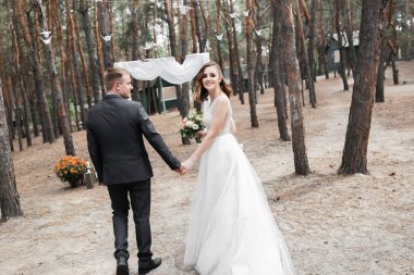 Parktaki düğün çifti. Avrupa görünümlü zarif bir gelin ve siyah takım elbiseli bir damat..