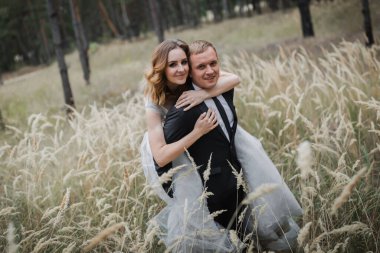 Parktaki düğün çifti. Avrupa görünümlü zarif bir gelin ve siyah takım elbiseli bir damat..