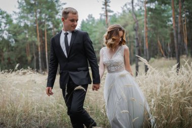 Parktaki düğün çifti. Avrupa görünümlü zarif bir gelin ve siyah takım elbiseli bir damat..