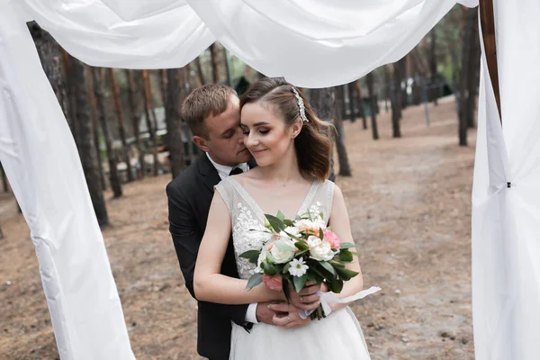 婚礼夫妇在公园里 一位优雅的欧洲新娘和身穿黑色西服的新郎 — 图库照片