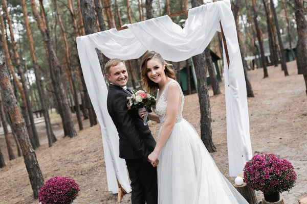 婚礼夫妇在公园里 一位优雅的欧洲新娘和身穿黑色西服的新郎 — 图库照片