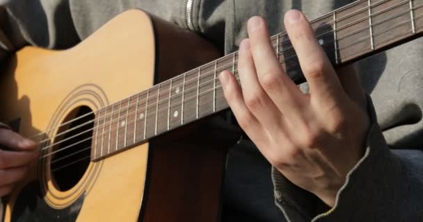 기타리스트는 어쿠스틱 기타를 클로즈업하고 탁트인 — 비디오