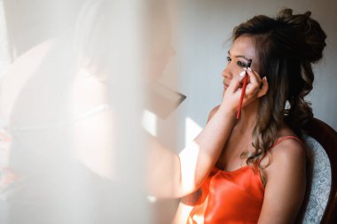 Gelin, otelde toplanıyor. Çiçek buketi ve peçe. Gün batımında uluslararası bir düğünde sevgili bir çift. Asya görünümlü güzel sofistike gelin.