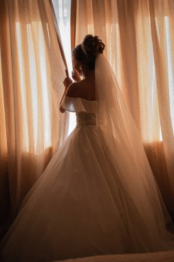 Gelin, otelde toplanıyor. Çiçek buketi ve peçe. Gün batımında uluslararası bir düğünde sevgili bir çift. Asya görünümlü güzel sofistike gelin.