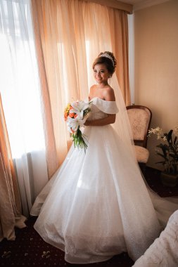 Gelin, otelde toplanıyor. Çiçek buketi ve peçe. Gün batımında uluslararası bir düğünde sevgili bir çift. Asya görünümlü güzel sofistike gelin.