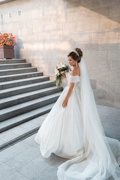 Gelinlik giymiş güzel bir Asyalı gelin gün batımında poz veriyor. Bir buket çiçek ve uzun bir peçe. Geleneksel parlak renklerde düğün dekoru. Filipin gelenekleri ve tatilleri.