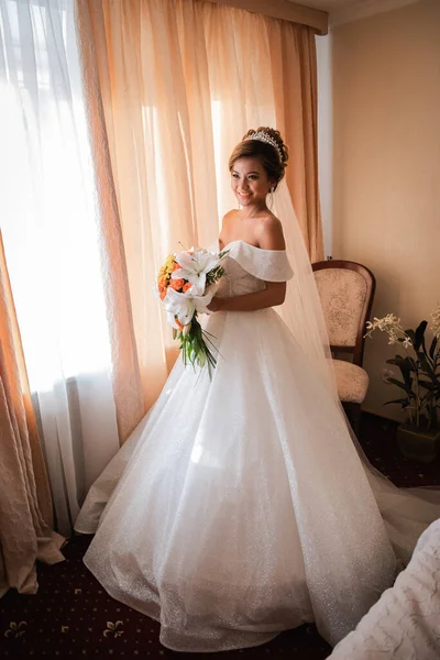 Gelin, otelde toplanıyor. Çiçek buketi ve peçe. Gün batımında uluslararası bir düğünde sevgili bir çift. Asya görünümlü güzel sofistike gelin.