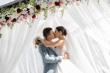 Ormanda yürüyüş için sevgili evlilik çifti. Gelinin güzel uzun bir duvağı ve siyah saçları var. Güneşli yaz günü