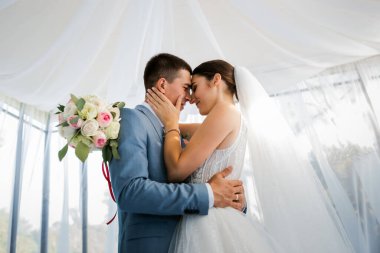 Ormanda yürüyüş için sevgili evlilik çifti. Gelinin güzel uzun bir duvağı ve siyah saçları var. Güneşli yaz günü