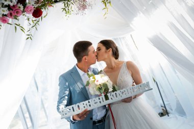 Ormanda yürüyüş için sevgili evlilik çifti. Gelinin güzel uzun bir duvağı ve siyah saçları var. Güneşli yaz günü