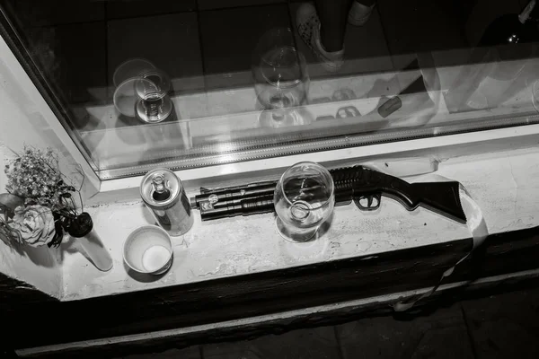 眼鏡とボトルの間に子供用のおもちゃの散弾銃があります — ストック写真