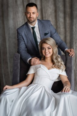 Stüdyoda birbirine aşık, gülümseyen bir çift el ele tutuşup sarılıyor. İyi ruh hali. Klasik çift portresi..