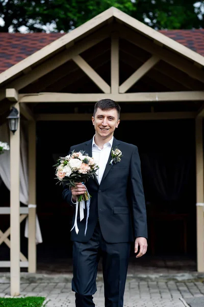 婚礼当天 优雅的新郎带着一束鲜花微笑 — 图库照片