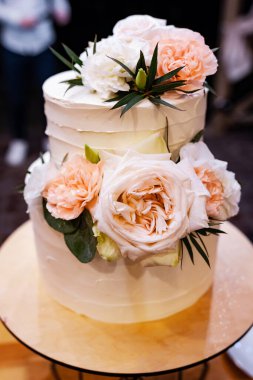 Taze çiçeklerle süslenmiş düğün pastası. İştah açıcı tatlılar