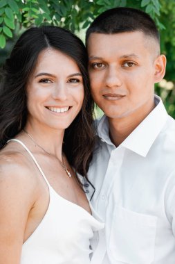 Düğün kıyafetleri içinde çok kültürlü mutlu bir çift. Gelinin beyaz bir buketi var. Göllü botanik bahçesi. Çin süslemeleri ve balıklar. Büyük portakal sazanları.