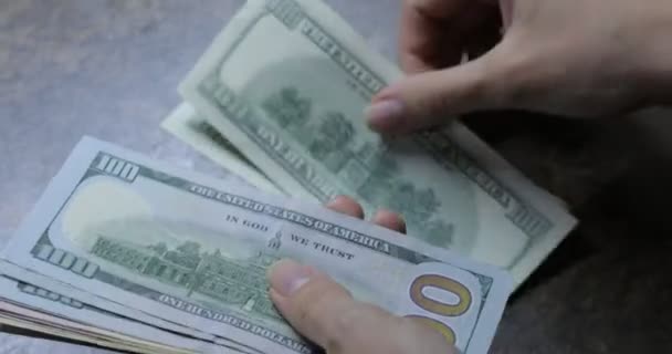 女性手中的美元放在木制桌子的背景上 一个女人拿着100美元和50美元的钞票 很多100美元的钞票 木制桌子上的钞票 — 图库视频影像