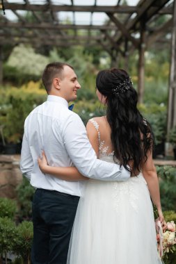 Düğün töreninden sonra mutlu gelin ve damat. Yeşil botanik bahçesinde yürü.