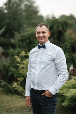 Papyonlu, beyaz gömlekli, çekici bir damat. Bir adamın portresi..