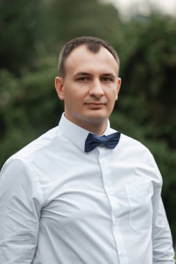 Papyonlu, beyaz gömlekli, çekici bir damat. Bir adamın portresi..