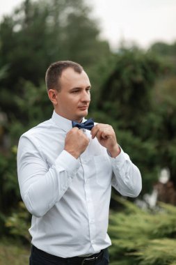 Papyonlu, beyaz gömlekli, çekici bir damat. Bir adamın portresi..