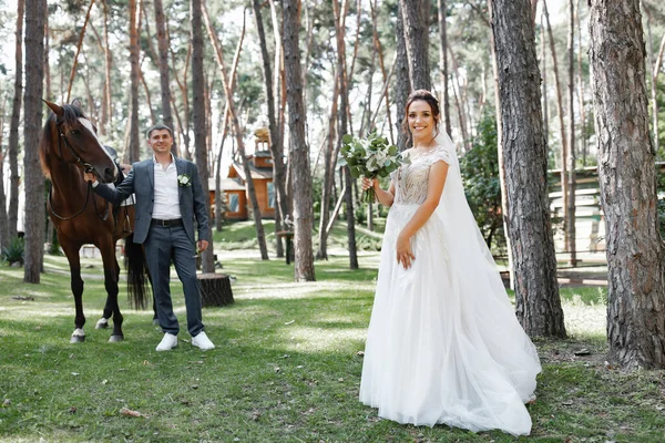 Genç ve evli bir çift ormanda yürüyüşe çıkmış kahverengi bir atla..