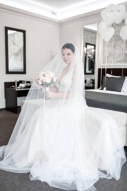 Çok güzel bir gelin otel odasında poz veriyor. Gün ışığı, doğal ışık, ferah oda.