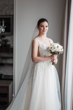 Çok güzel bir gelin otel odasında poz veriyor. Gün ışığı, doğal ışık, ferah oda.