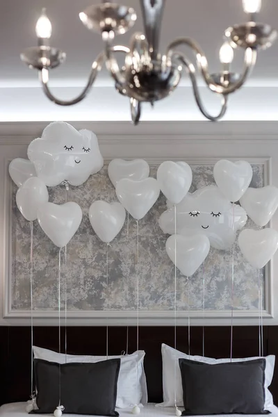 White balloons in the shape of clouds with a smile.