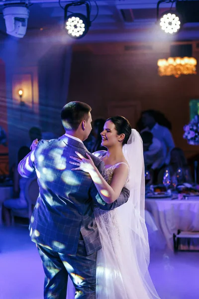 The wedding couple dances, with thick stage smoke billowing around them. Pink and blue lights