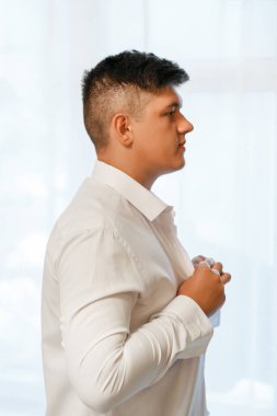 Adam beyaz bir gömlek giymiş, neşeli bir ruh hali içinde. Beyaz arkaplan