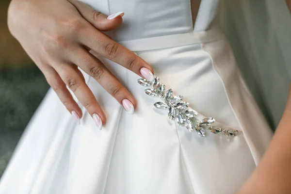 Chic wedding dress, pocket close-up. The bride\'s hands