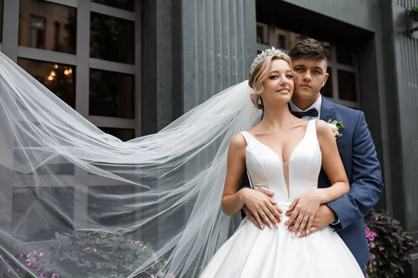Güzel bir evin önünde birbirine aşık bir çift. Sarışın gelinin kafasında bir taç ve uzun güzel bir peçe var. Damat mavi, zarif bir takım elbise giymiş..