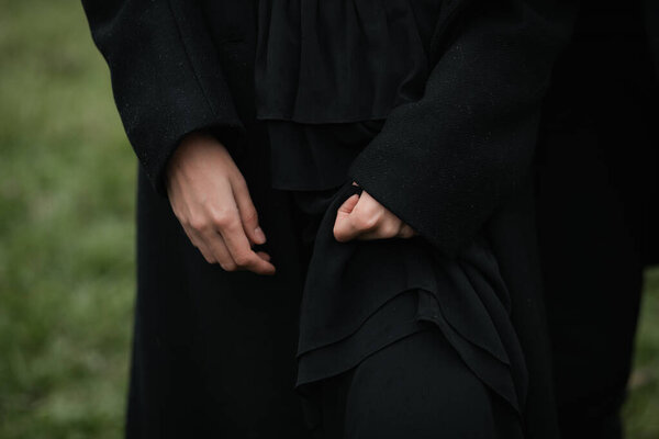 A man in a black coat, hands close up. Sad autumn mood.