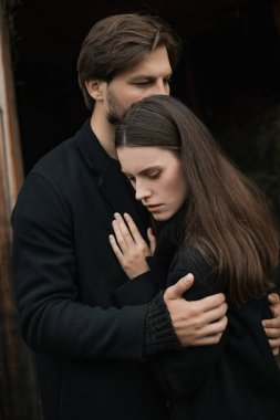 Siyah paltolu genç bir çift yağmurda kırsalda yürür. Sonbahar kasvetli havası. Sinematik görüntü