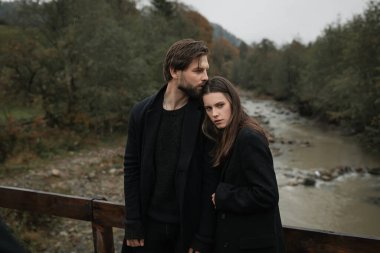 Siyah paltolu genç bir çift yağmurda kırsalda yürür. Sonbahar kasvetli havası. Sinematik görüntü