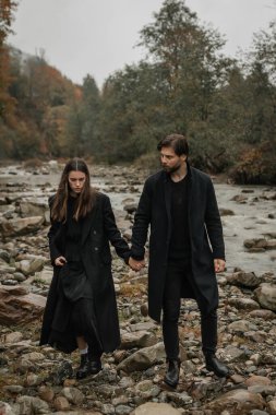 Siyah paltolu genç bir çift yağmurda kırsalda yürür. Sonbahar kasvetli havası. Sinematik görüntü