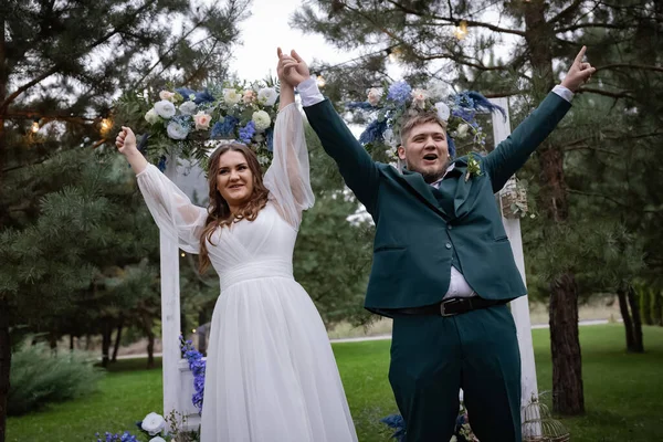 曲线的人 婚礼夫妇在散步 时尚迷人的新娘 穿着绿色西装的新郎 美丽的公园 — 图库照片