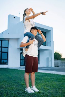 Genç, neşeli bir çift, güzel bir parkta, yeşil çimenli bir yatakta, meyveli, mutlu bir şekilde yatıyor..