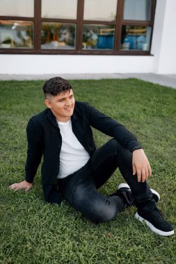 Genç, neşeli bir çift, güzel bir parkta, yeşil çimenli bir yatakta, meyveli, mutlu bir şekilde yatıyor..