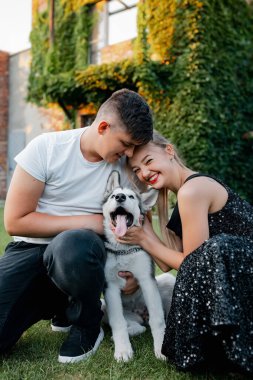 Komik, oyuncu köpek. Güzel bir parkta genç, sevgi dolu ve neşeli bir çift. Nehir manzarası ve Beyaz Saray. İri köpek etrafta dolaşıyor.