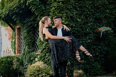 Genç, neşeli bir çift, güzel bir parkta, yeşil çimenli bir yatakta, meyveli, mutlu bir şekilde yatıyor..