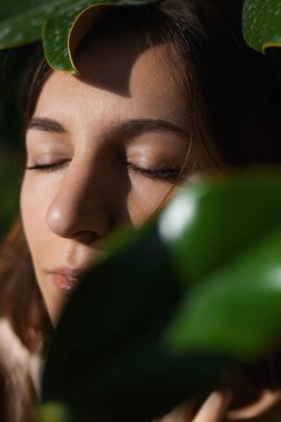 Tropikal bitkilerin arasında gülen neşeli bir kız.. 